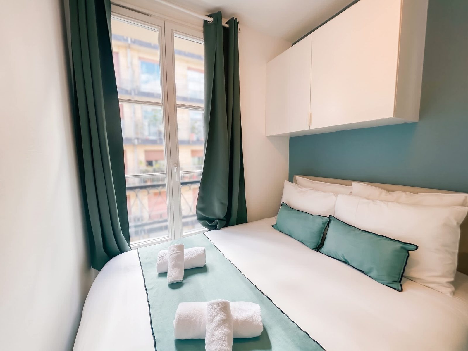 Chambre aux rideaux vert profond et mur bleu-vert