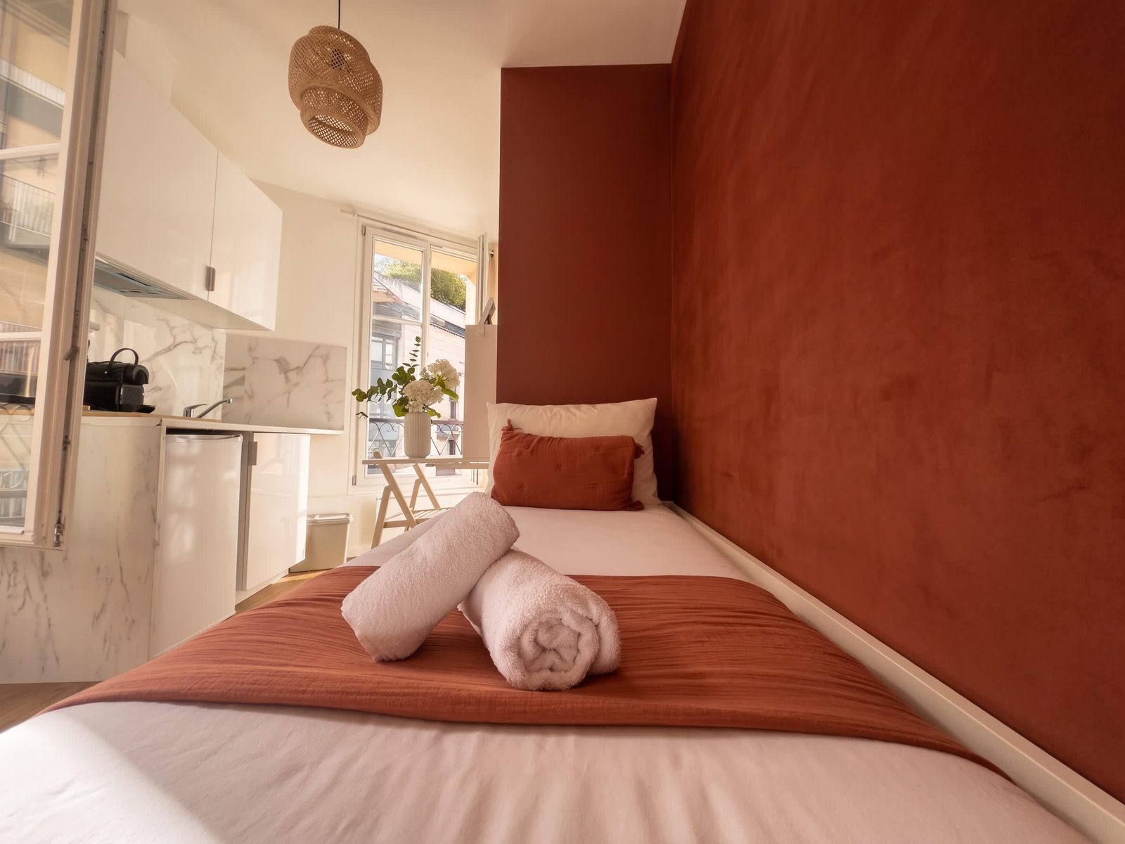 Lit et linge blanc sur mur terracotta